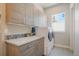 This laundry room has a utility sink, lots of cabinet storage, and modern appliances at 670 Portland Rd, Monument, CO 80132