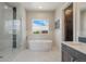 View of the main bath with standalone tub, marble shower and wainscotting at 670 Portland Rd, Monument, CO 80132