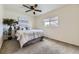 Cozy bedroom with ceiling fan, neutral carpet and walls, and a sun-filled window at 7822 South Kittredge Circle, Englewood, CO 80112