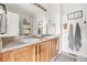 Bright bathroom featuring double sinks, a large mirror, and neutral decor with wood cabinets at 5428 Zephyr Ct, Arvada, CO 80002