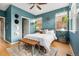 Stylish bedroom with an area rug, bench, bright windows, blue accent wall, and modern decor at 5428 Zephyr Ct, Arvada, CO 80002