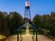 Charming view of the town water tower at dusk, framed by lush greenery and a modern walkway at 5428 Zephyr Ct, Arvada, CO 80002