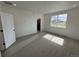 Bright, carpeted bedroom with a large window and a glimpse of the en-suite bathroom at 2141 S Irvington St, Aurora, CO 80018