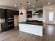 Modern kitchen with dark cabinets, stainless steel appliances, and a large island with pendant lighting at 2141 S Irvington St, Aurora, CO 80018