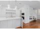 Bright kitchen with marble waterfall island, stainless appliances, white cabinets, and wood floors at 2950 E 17Th Ave, Denver, CO 80206