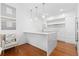 Bright kitchen with marble waterfall island, modern pendant lights, white cabinets, and wood floors at 2950 E 17Th Ave, Denver, CO 80206