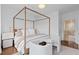 Bright main bedroom featuring four-poster bed, chairs and view to ensuite bathroom at 2950 E 17Th Ave, Denver, CO 80206