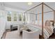 Bright main bedroom featuring four-poster bed, bench and chairs with large windows at 2950 E 17Th Ave, Denver, CO 80206