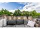 Comfortable outdoor seating area on a balcony with a view of lush greenery and a blue sky with clouds at 2950 E 17Th Ave, Denver, CO 80206