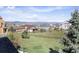 A scenic view of the backyard overlooking neighborhood homes and mountains in the distance under a sunny sky at 3893 Ute Mountain Trl, Castle Rock, CO 80109
