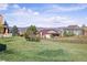 Landscaped backyard featuring a grassy area and mature trees; mountain views in the distance at 3893 Ute Mountain Trl, Castle Rock, CO 80109