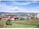 Scenic view of the community showcasing well-maintained homes, a grassy field, and the Rocky Mountains in the distance at 3893 Ute Mountain Trl, Castle Rock, CO 80109