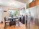 Cozy dining area with hardwood floors, a window view, a modern light fixture, and stainless steel refrigerator at 3893 Ute Mountain Trl, Castle Rock, CO 80109
