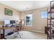 A home office with a large desk and monitors is well-lit by natural light at 3893 Ute Mountain Trl, Castle Rock, CO 80109