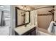 Well-lit bathroom featuring a bathtub with shower and dark-trimmed mirror at 27732 Squaw Pass Rd, Evergreen, CO 80439