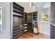 A walk-in closet with custom shelving and drawers for ample storage, lit by a modern light fixture at 27732 Squaw Pass Rd, Evergreen, CO 80439