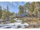 Blue home on a hillside, featuring a large deck and screened-in porch, surrounded by natural landscape at 27732 Squaw Pass Rd, Evergreen, CO 80439