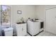 Functional laundry room featuring a modern washer and dryer, utility sink, and natural light at 27732 Squaw Pass Rd, Evergreen, CO 80439