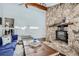 Vaulted living room with a unique stone fireplace, wood beam and leather ottoman at 27732 Squaw Pass Rd, Evergreen, CO 80439