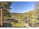 Scenic mountain view from the property, showcasing a lush forest under a clear blue sky at 27732 Squaw Pass Rd, Evergreen, CO 80439