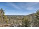 Expansive mountain view with snow visible, framed by lush trees and a clear blue sky at 27732 Squaw Pass Rd, Evergreen, CO 80439