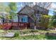 Backyard view featuring a wooden deck, well-maintained lawn, landscaping, and mature trees, creating a peaceful retreat at 25871 E 5Th Pl, Aurora, CO 80018