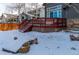 Backyard with snow cover featuring a large wooden deck, and a gray house at 25871 E 5Th Pl, Aurora, CO 80018