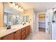 Bathroom with double vanity, granite countertops, and a tiled walk-in shower at 25871 E 5Th Pl, Aurora, CO 80018