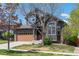 Charming two-story home showcasing stone accents, brown siding, a well-manicured lawn, and a two-car garage at 25871 E 5Th Pl, Aurora, CO 80018