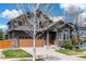 Charming two-story home showcasing stone accents, brown siding, a well-manicured lawn, and a two-car garage at 25871 E 5Th Pl, Aurora, CO 80018