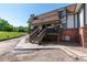 Charming townhouse with a brick facade, covered porch and stairs leading to the entrance at 2700 S Holly St # 115, Denver, CO 80222