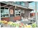 Outdoor dining at La Fogata, featuring brick walls, flower boxes, and garage door style windows at 2700 S Holly St # 115, Denver, CO 80222