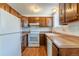 Functional kitchen featuring wood cabinets, laminate countertops, a white refrigerator, and a white oven at 2700 S Holly St # 115, Denver, CO 80222