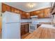 Functional kitchen featuring wood cabinets, laminate countertops, and white appliances at 2700 S Holly St # 115, Denver, CO 80222