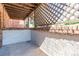 Exterior patio area featuring brick walls, wooden lattice, and concrete flooring at 2700 S Holly St # 115, Denver, CO 80222