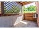 Covered outdoor patio area with brick wall, wooden fence, and open lattice overhead at 2700 S Holly St # 115, Denver, CO 80222