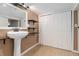 Modest bathroom with pedestal sink, decorative floors, and wood-trimmed shelving at 5123 Milwaukee St, Denver, CO 80216