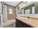 Well-lit bathroom featuring a shower-tub combo, tiled floors and walls, and wainscotting at 5123 Milwaukee St, Denver, CO 80216