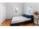 Bedroom with hardwood floors, neutral walls, and a comfortable bed under a window at 5123 Milwaukee St, Denver, CO 80216