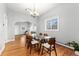 Bright dining room with hardwood floors, a modern chandelier, and a large window overlooking the yard at 5123 Milwaukee St, Denver, CO 80216