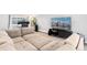 Open living room featuring a large modular couch, entertainment center, and home office setup at 5123 Milwaukee St, Denver, CO 80216