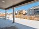 View of backyard from covered patio, snowy ground and wooden fence at 3826 N Elk St, Aurora, CO 80019