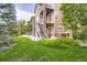 Beautiful backyard featuring a multi-level patio, lush green lawn, and mature trees at 4965 Huntwick Pl, Highlands Ranch, CO 80130
