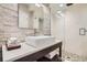 Modern bathroom with stone accent wall, vessel sink, glass shower, and pebble flooring at 4965 Huntwick Pl, Highlands Ranch, CO 80130
