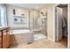 Bright bathroom with a tub and shower, and floating shelves at 4965 Huntwick Pl, Highlands Ranch, CO 80130
