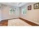 Cozy bedroom with hardwood floors, neutral walls, two windows with blinds, and a soft rug at 4965 Huntwick Pl, Highlands Ranch, CO 80130