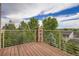 Spacious wood deck with metal railings, offering stunning views of the surrounding greenery at 4965 Huntwick Pl, Highlands Ranch, CO 80130