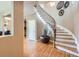 Foyer featuring hardwood floors and a curved staircase with decorative wrought iron at 4965 Huntwick Pl, Highlands Ranch, CO 80130