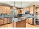Kitchen features hardwood floors, wood cabinets, island, mosaic backsplash, and stainless steel appliances at 4965 Huntwick Pl, Highlands Ranch, CO 80130
