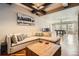 Open living room with a comfortable sectional sofa, coffered ceiling, hardwood floors, and pool table in background at 4965 Huntwick Pl, Highlands Ranch, CO 80130